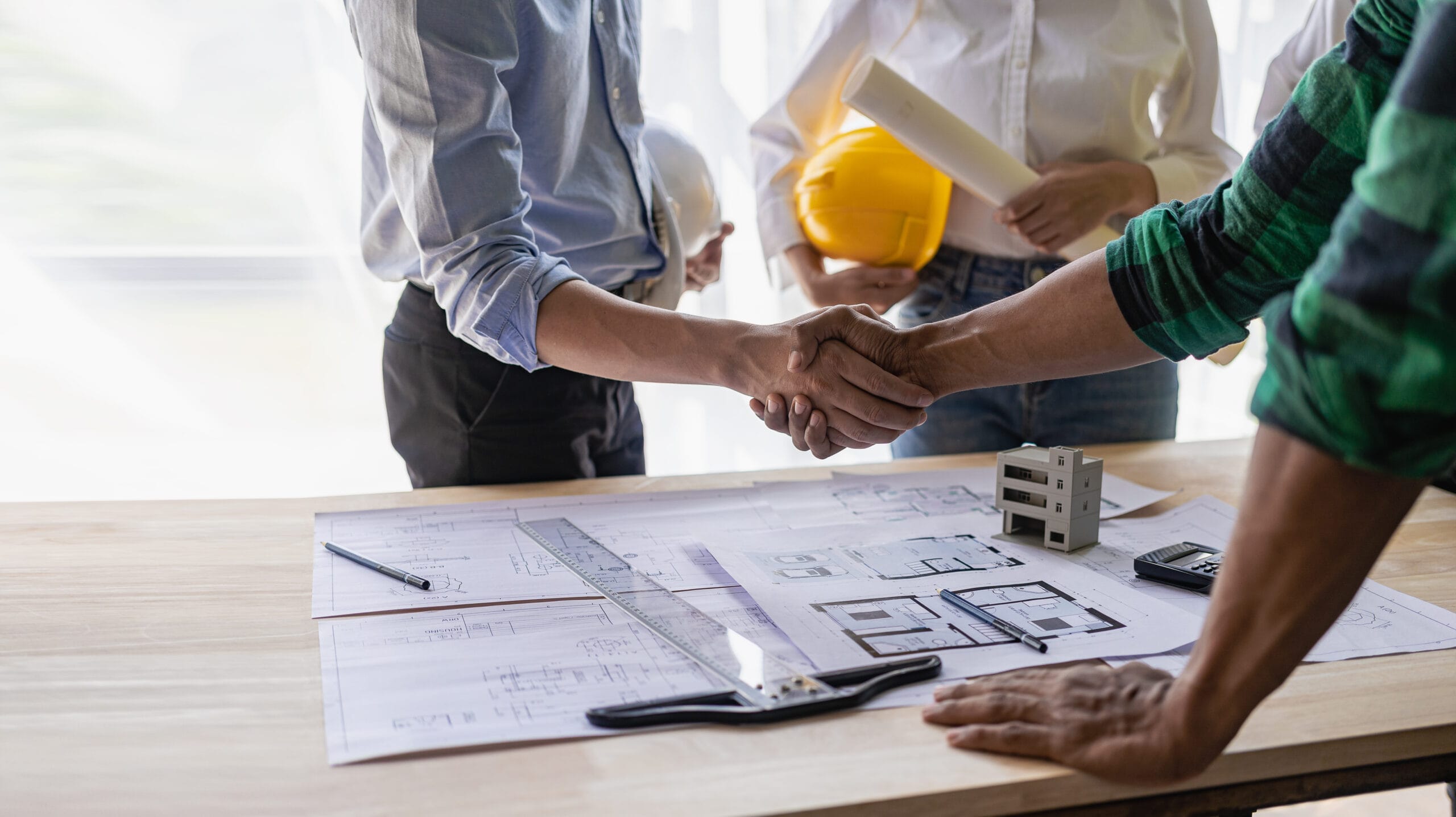 yellow-hard-hat-on-table-and-house-design-print-design-with-construction-team-handshake-greeting-start-new-project-contract-plan-in-office-center-at-construction-site-partner-and-contractor-stockpack-adobe-stock Yellow hard hat on table and house design print design with construction team handshake greeting start new project contract plan in office center at construction site partner and contractor