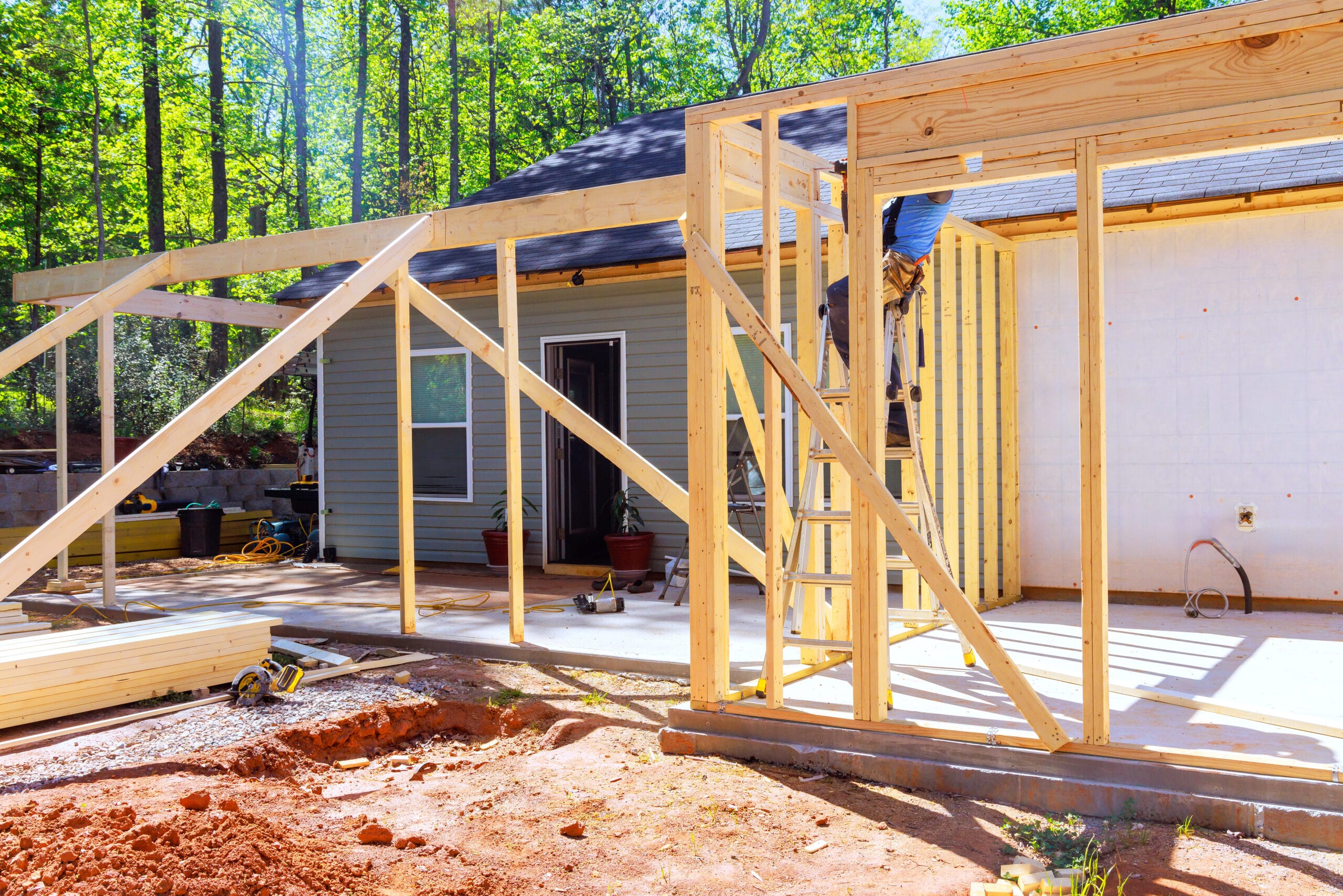 workers-install-wooden-beams-for-home-extension-in-wooded-area-during-trusses-frame-stockpack-adobe-stock Workers install wooden beams for home extension in wooded area during trusses frame
